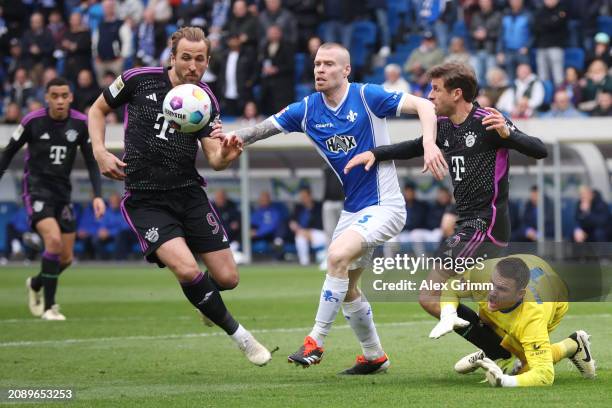 Harry Kane and Thomas Mueller of Bayern Muenchen battle for possession with Thomas Isherwood and Marcel Schuhen of Darmstadt during the Bundesliga...