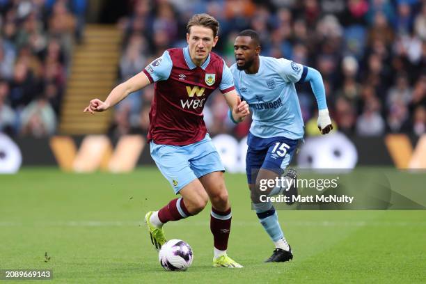 Sander Berge of Burnley dribbles with the ball under pressure from Frank Onyeka of Brentford during the Premier League match between Burnley FC and...