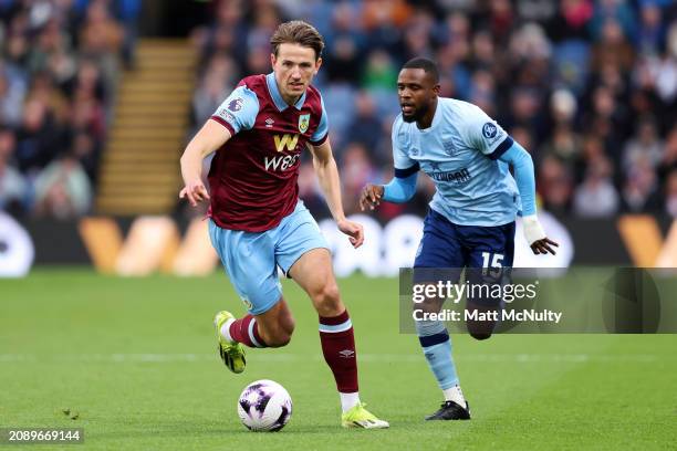 Sander Berge of Burnley dribbles with the ball under pressure from Frank Onyeka of Brentford during the Premier League match between Burnley FC and...