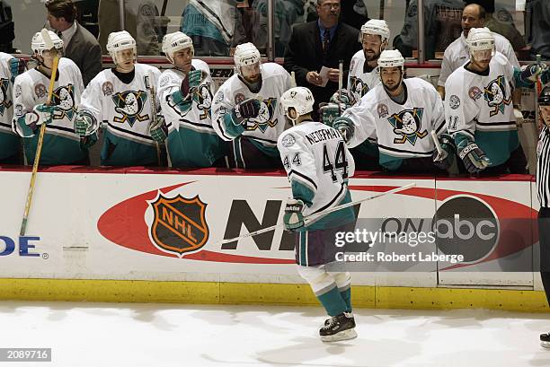 Rob Niedermayer of the Mighty Ducks of Anaheim is congratulated by his teammates as he skates by the bench against the New Jersey Devils in game six...