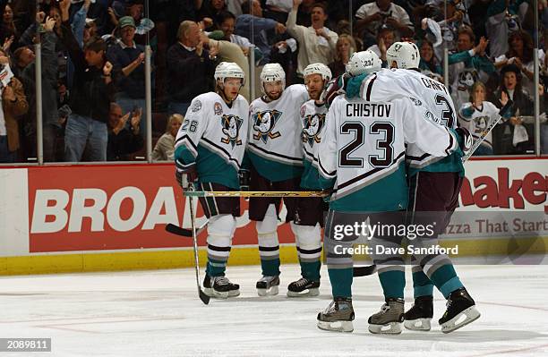 Keith Carney and Stanislav Chistov of the Mighty Ducks of Anaheim make their way toward teammates to celebrate a goal against the New Jersey Devils...