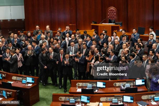 John Lee, Hong Kong's chief executive, front center, applauses with lawmakers following the passing of Basic Law Article 23 legislation at the...