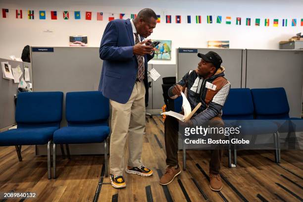 Boston, MA Pastor Dieufort Fleurissaint, aka 'Pastor Keke,' helps fellow Haitian immigrant, Wilner Jn Pierre with questions about renewing a drivers...