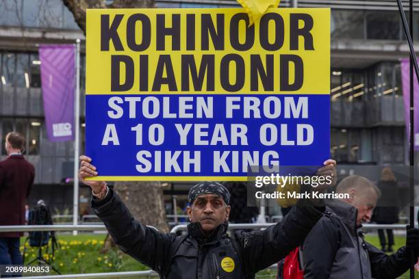 Man attending a protest opposite Westminster Abbey on Commonwealth Day by anti-monarchy group Republic holds up a sign referring to the Koh-i-Noor...