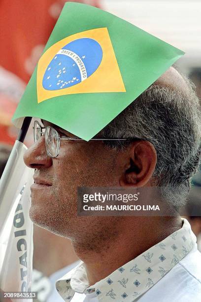 Worker is seen protecting himslef from the sun with a flag 22 October 2001. Un obrero metalurgico brasileno se proteje del sol con una bandera de...