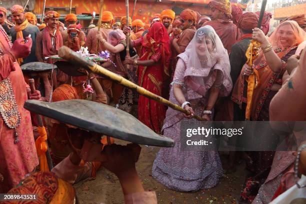 Women of the town Nandgaon beat men from the town of Barsana during Lathmar Holi celebrations, the Hindu spring festival of colours, at Nandgaon in...