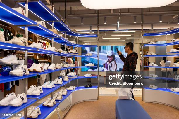 Customer takes a photograph of shoes at a MLB store in the Myeongdong shopping district in Seoul, South Korea, on Saturday, March 9, 2024. The MLB...