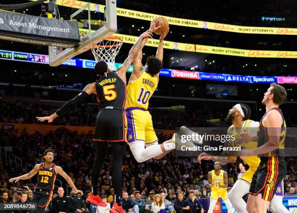 Los Angeles Lakers guard Max Christie is fouled by Atlanta Hawks guard Dejounte Murray as he flys through the air for a dunk in the first half at...