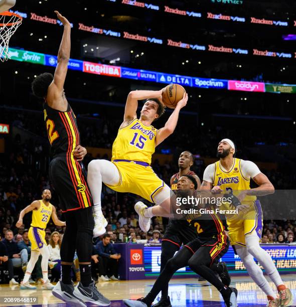 Los Angeles Lakers guard Austin Reaves passes off at the last minute against Atlanta Hawks forward De'Andre Hunter in the first half at Crypto.com...
