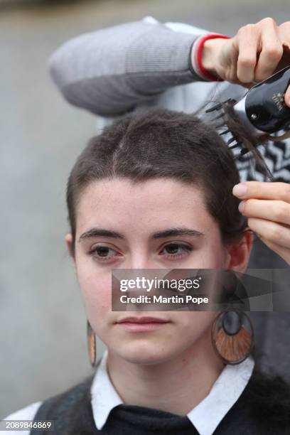 Protester is left with a crop after her chest long hair id shaved off by a colleague outside the Houses of Parliament on March 19, 2024 in London,...