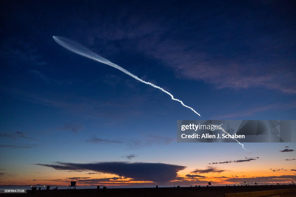 The launch of SpaceX Falcon 9 rocket with 22 Starlink satellites is viewed from Huntington Beach at dusk after taking off from Vandenberg Space Force Base.