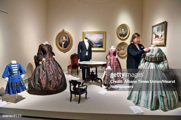 Curator Diane Shewchuk puts a finishing touch to an 1850's parlor installation at Albany Institute of History & Art's new exhibit on "Well-Dressed...