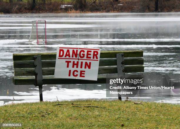 Danger Thin Ice sign with the remnants of a pond hockey rink beyond Friday Jan. 12, 2018 in Clifton Park, NY.