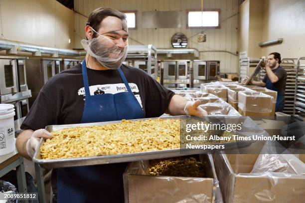 Roaster Jon Doty with a tray of salted cashew pieces in the roasting room at the Tierra Farm production facility and retail store Friday March 9,...