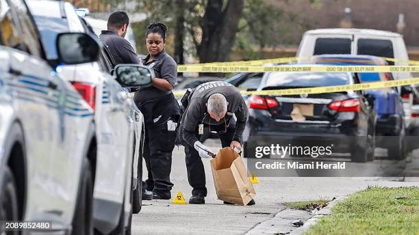 Miami crime scene investigators gather evidence after police shot a man near Northwest Seventh Court and 57th Street in Miami, on Thursday, March 7,...