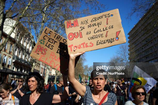 Woman is holding a cardboard sign that reads 'No to level groups, yes to one high school, all together' in Toulouse, France, on March 19, 2024....