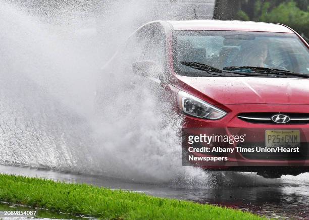 Motorist splashes through a puddle along Wolf Road on a rainy Wednesday afternoon July 25, 2018 in Colonie, NY.