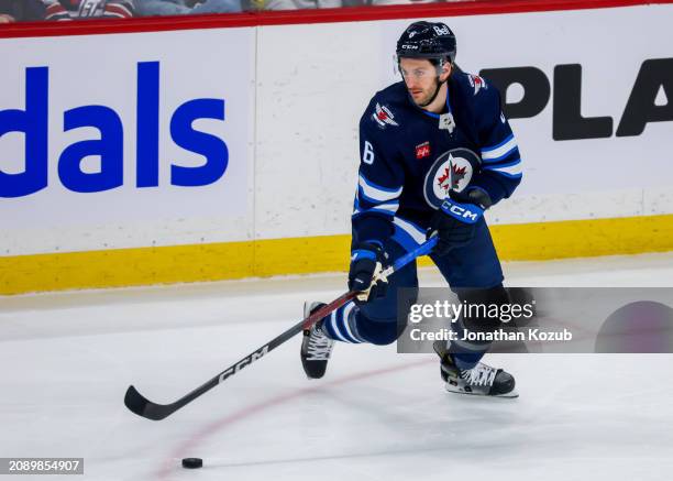 Colin Miller of the Winnipeg Jets plays the puck during third period action against the Nashville Predators at Canada Life Centre on March 13, 2024...