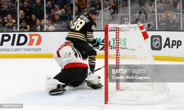 David Pastrnak of the Boston Bruins scores his second goal of the game against Joonas Korpisalo of the Ottawa Senators at the TD Garden on March 19,...