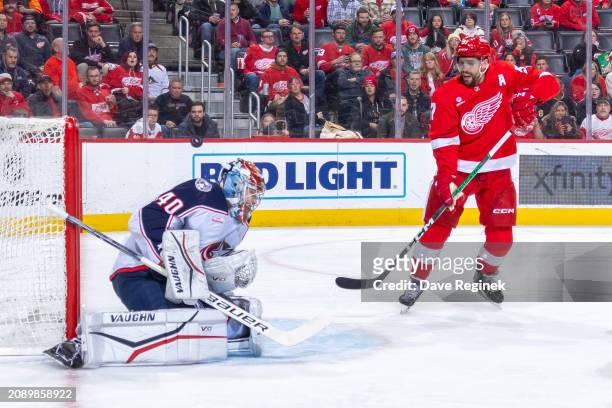 Daniil Tarasov of the Columbus Blue Jackets makes a save as David Perron of the Detroit Red Wings looks for the rebound during the first period at...