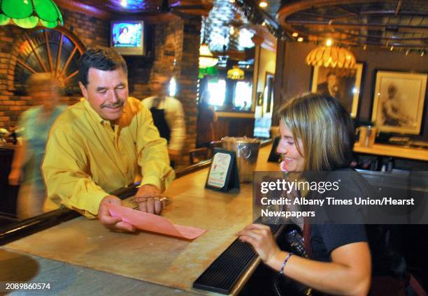 Times Union staff photo by John Carl D'Annibale: Restaurant owner Ray Morris,left, reviews specials with employee and recent college graduate Megan...