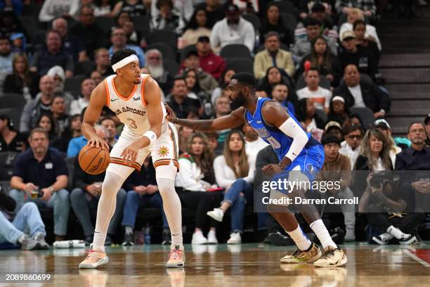 Keldon Johnson of the San Antonio Spurs handles the ball during the game against the Dallas Mavericks on March 19, 2024 at the Frost Bank Center in...