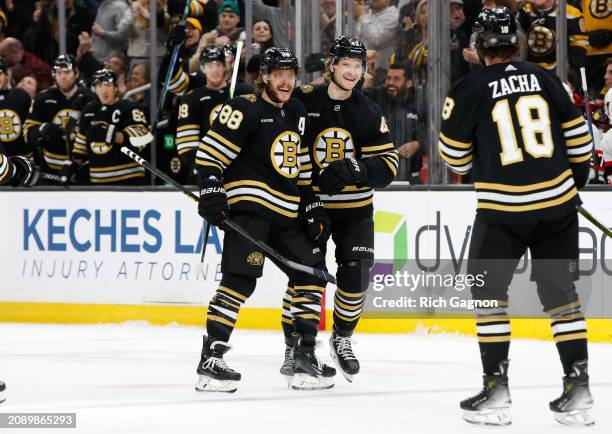 David Pastrnak of the Boston Bruins celebrates his hat trick against the Ottawa Senators with teammate Danton Heinen during the third period at the...