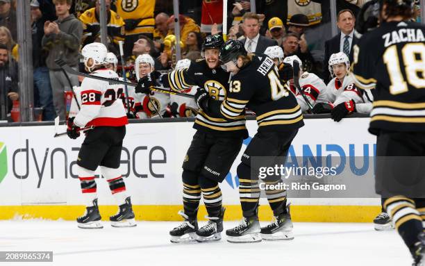 David Pastrnak of the Boston Bruins celebrates his hat trick against the Ottawa Senators with teammate Danton Heinen during the third period at the...