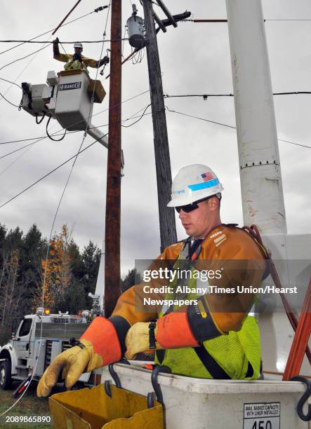 National Grid lineman Nate Johnson prepares to go up in a bucket truck as crews work to replace 75 utility poles between Vail Mills and Galway Friday...