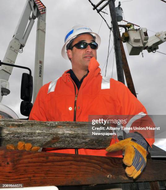 National Grid overhead lines manager Mike Martuscello with examples of new and old utility pole cross members as his crews work to replace 75 utility...