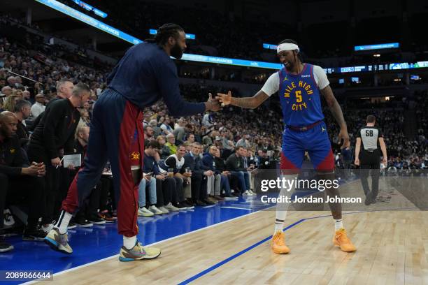 Kentavious Caldwell-Pope high fives DeAndre Jordan of the Denver Nuggets during the game against the Minnesota Timberwolves on March 19, 2024 at...