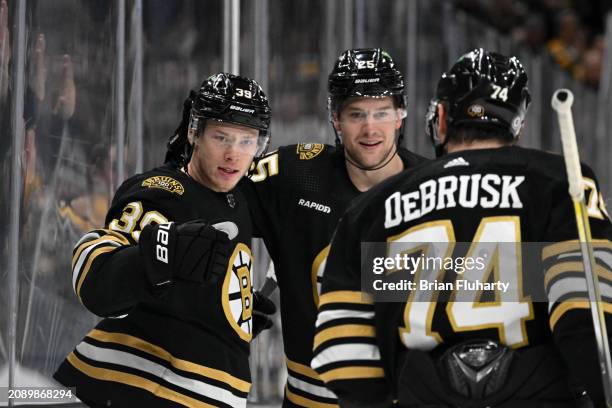 Morgan Geekie of the Boston Bruins celebrates with Brandon Carlo and Jake DeBrusk after scoring a goal against the Philadelphia Flyers during the...