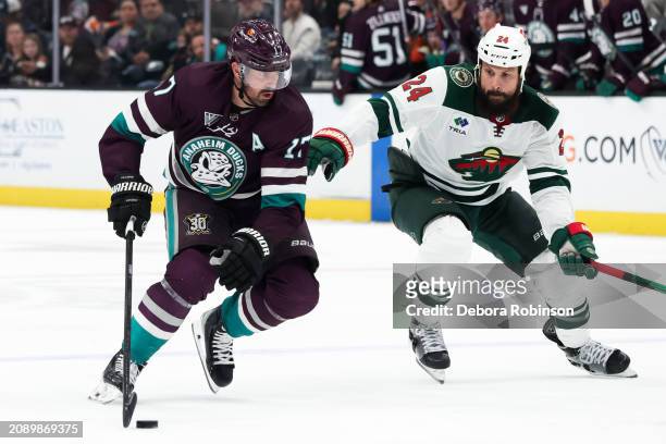 Alex Killorn of the Anaheim Ducks skates with the puck with pressure from Zach Bogosian of the Minnesota Wild during the game on March 19, 2024 at...