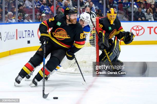 Casey DeSmith looks on as Ian Cole of the Vancouver Canucks is pursued by Eric Robinson of the Buffalo Sabres during the second period of their NHL...