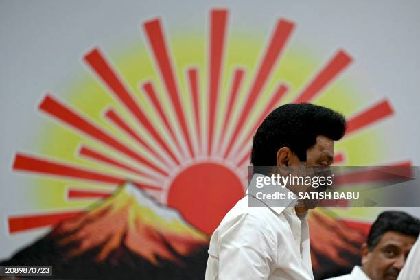 Chief Minister of India's Tamil Nadu state and Dravida Munnetra Kazhagam party president MK Stalin walks past the party symbol after releasing their...