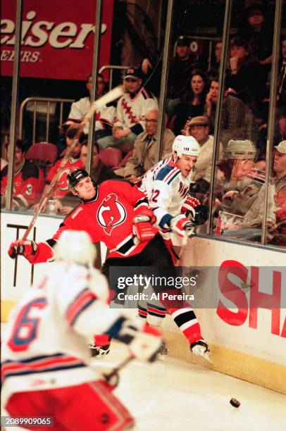 Defenseman Colin White of the New Jersey Devils throws a hard hit on RW Mike Knuble of the New York Rangers in the game between the New Jersey Devils...