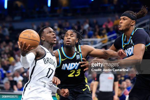 Dennis Schroder of the Brooklyn Nets drives to the basket against Aaron Nesmith and Myles Turner of the Indiana Pacers during the first half at...