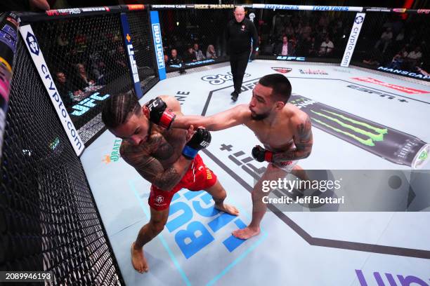 Christian Rodriguez punches Isaac Dulgarian in their featherweight fight during the UFC Fight Night event at UFC APEX on March 16, 2024 in Las Vegas,...