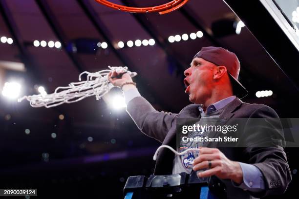 Head coach Dan Hurley of the Connecticut Huskies cuts a piece of the net after winning the game against the Marquette Golden Eagles during the Big...