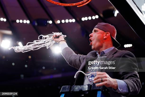 Head coach Dan Hurley of the Connecticut Huskies cuts a piece of the net after winning the game against the Marquette Golden Eagles during the Big...