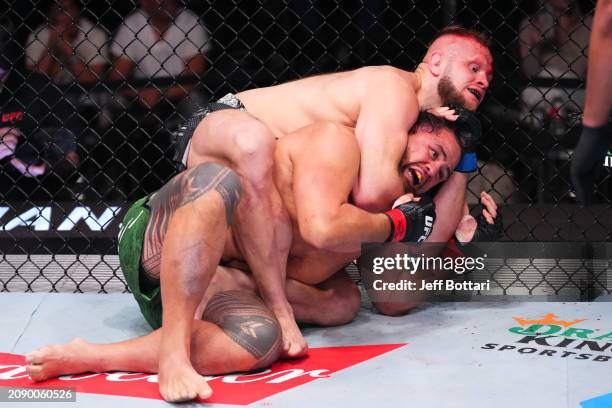 Marcin Tybura of Poland attempts to submit Tai Tuivasa of Australia in their heavyweight fight during the UFC Fight Night event at UFC APEX on March...