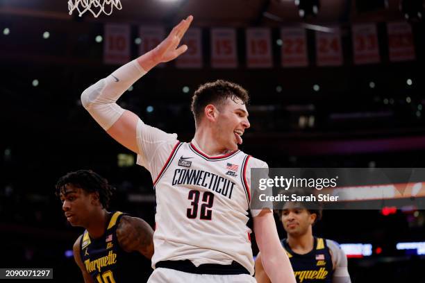 Donovan Clingan of the Connecticut Huskies reacts after dunking the ball in the second half against the Marquette Golden Eagles during the Big East...