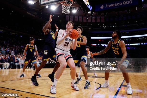 Donovan Clingan of the Connecticut Huskies goes to the basket as Zaide Lowery, Oso Ighodaro, and David Joplin defend in the second half during the...