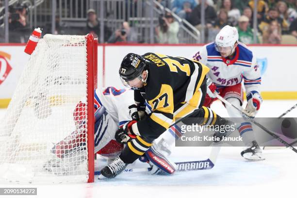 Jeff Carter of the Pittsburgh Penguins trips over Jonathan Quick of the New York Rangers at PPG PAINTS Arena on March 16, 2024 in Pittsburgh,...