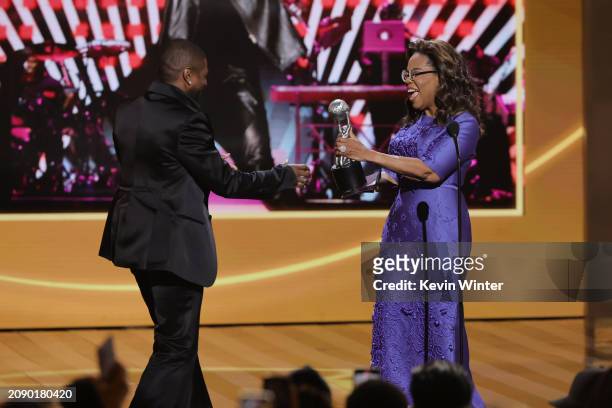 Usher accepts the Entertainer of the Year award from Oprah Winfrey onstage during the 55th Annual NAACP Awards at the Shrine Auditorium and Expo Hall...