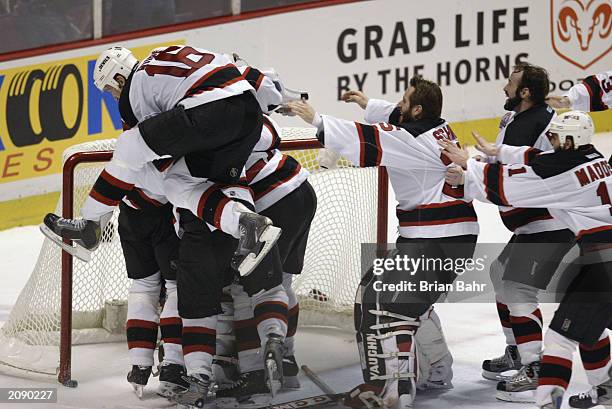 Mike Rupp of the New Jersey Devils leaps into the air as he celebrates with his teammates after defeating the Mighty Ducks of Anaheim in game seven...