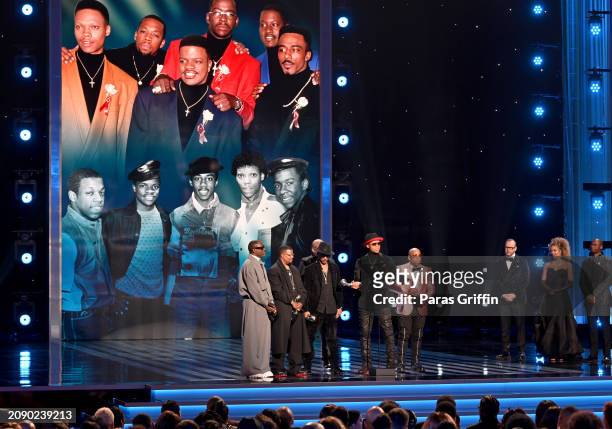 Johnny Gill, Ricky Bell, Ralph Tresvant, Bobby Brown, Ronnie DeVoe and Michael Bivins of New Edition speak onstage during the 55th NAACP Image Awards...