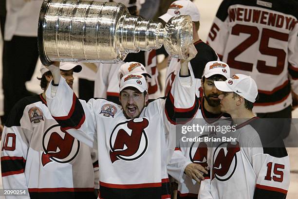 Mike Rupp of the New Jersey Devils raises the Stanley Cup as he celebrates the win over the Mighty Ducks of Anaheim in game seven of the 2003 Stanley...