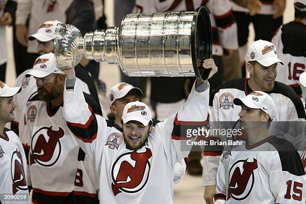 Oleg Tverdovsky of the New Jersey Devils raises the Stanley Cup as he celebrates the win over the Mighty Ducks of Anaheim in game seven of the 2003...