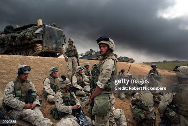 Marines from the 1st Marine Division get set to deploy into a blocking position April 8, 2003 near a Iraqi Army compound under attack 6-8 miles south...